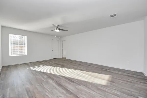 wooden floor in an empty room with a window