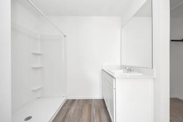 an empty room with windows and ceiling fan