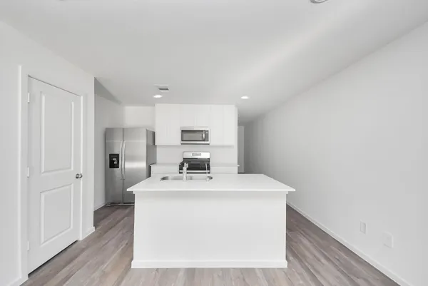 a kitchen with stainless steel appliances a sink stove top oven and white cabinets