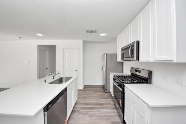 a kitchen that has a sink and a stove top oven
