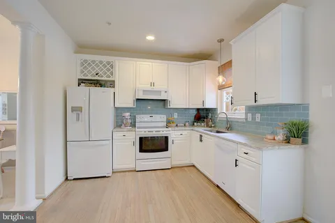 a kitchen with white cabinets and white appliances