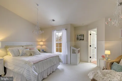 a bedroom with a bed and a view of living room