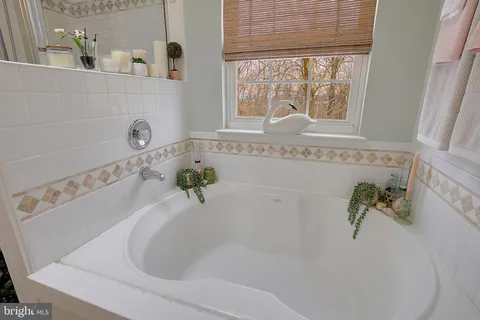 a white bath tub sitting in a bathroom next to a window
