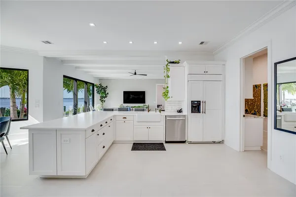 a large white kitchen with cabinets