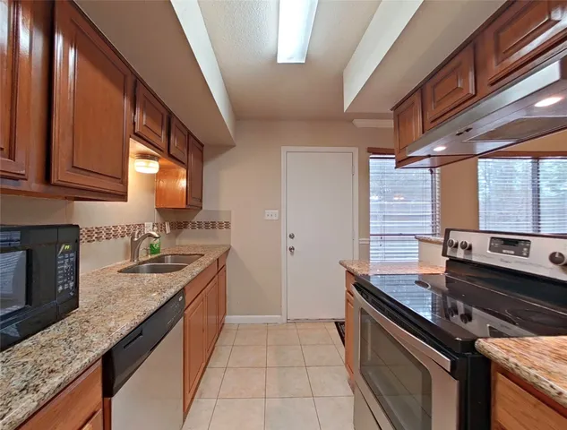 a kitchen with stainless steel appliances granite countertop a sink stove and cabinets
