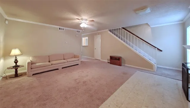 a living room with furniture and a ceiling fan