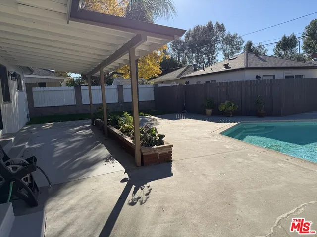 a patio with table and chairs with wooden fence