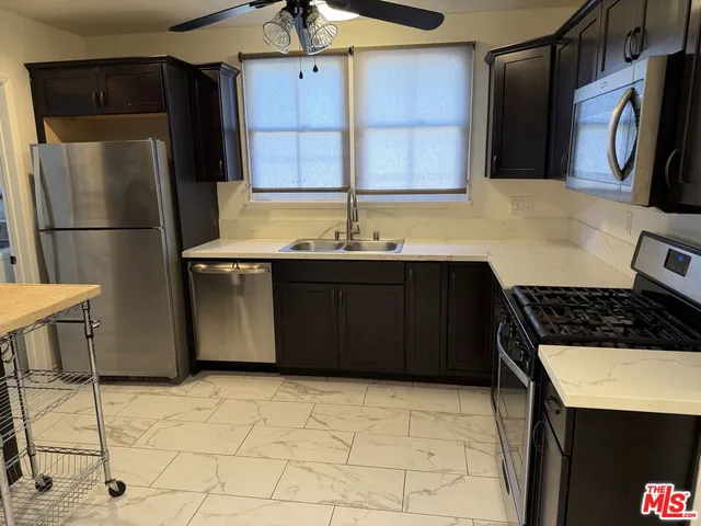 a kitchen with a sink a refrigerator and cabinets