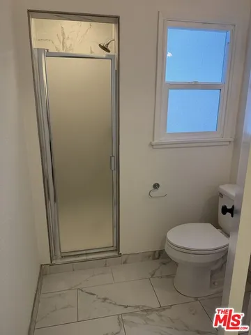 a bathroom with a toilet and a shower