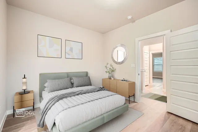 a bedroom with a bed and wooden floor