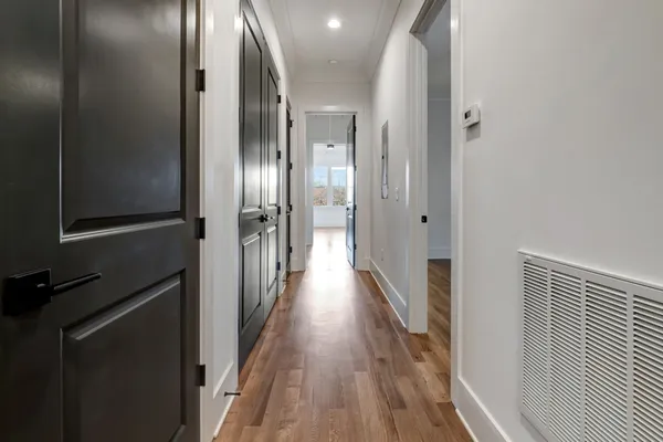 an empty room with wooden floor and hallway