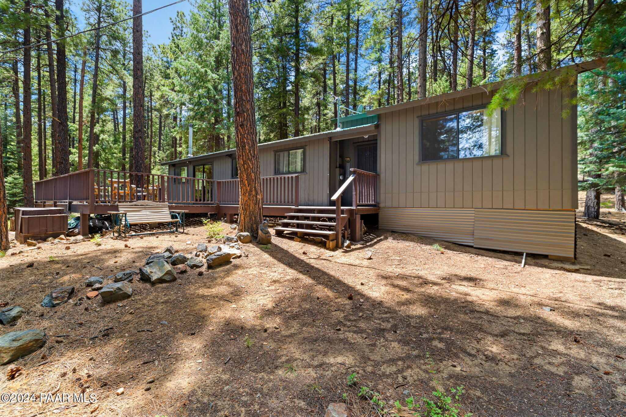 a backyard of a house with wooden fence and a bench