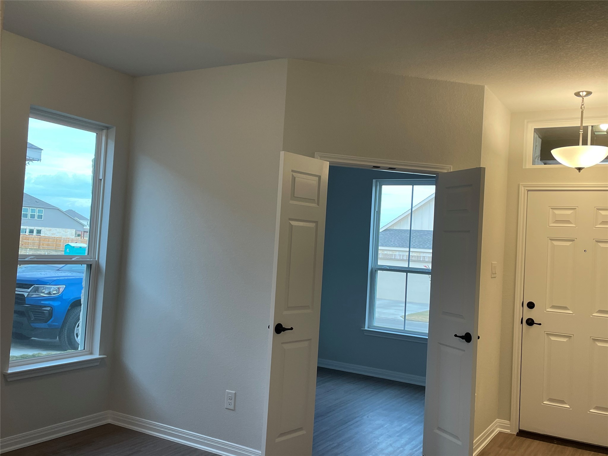 3908 Birdwatch Loop, Unit 56 Pflugerville, TX 78660 - Photo 3 of 30 a view of an empty room with wooden floor and a window