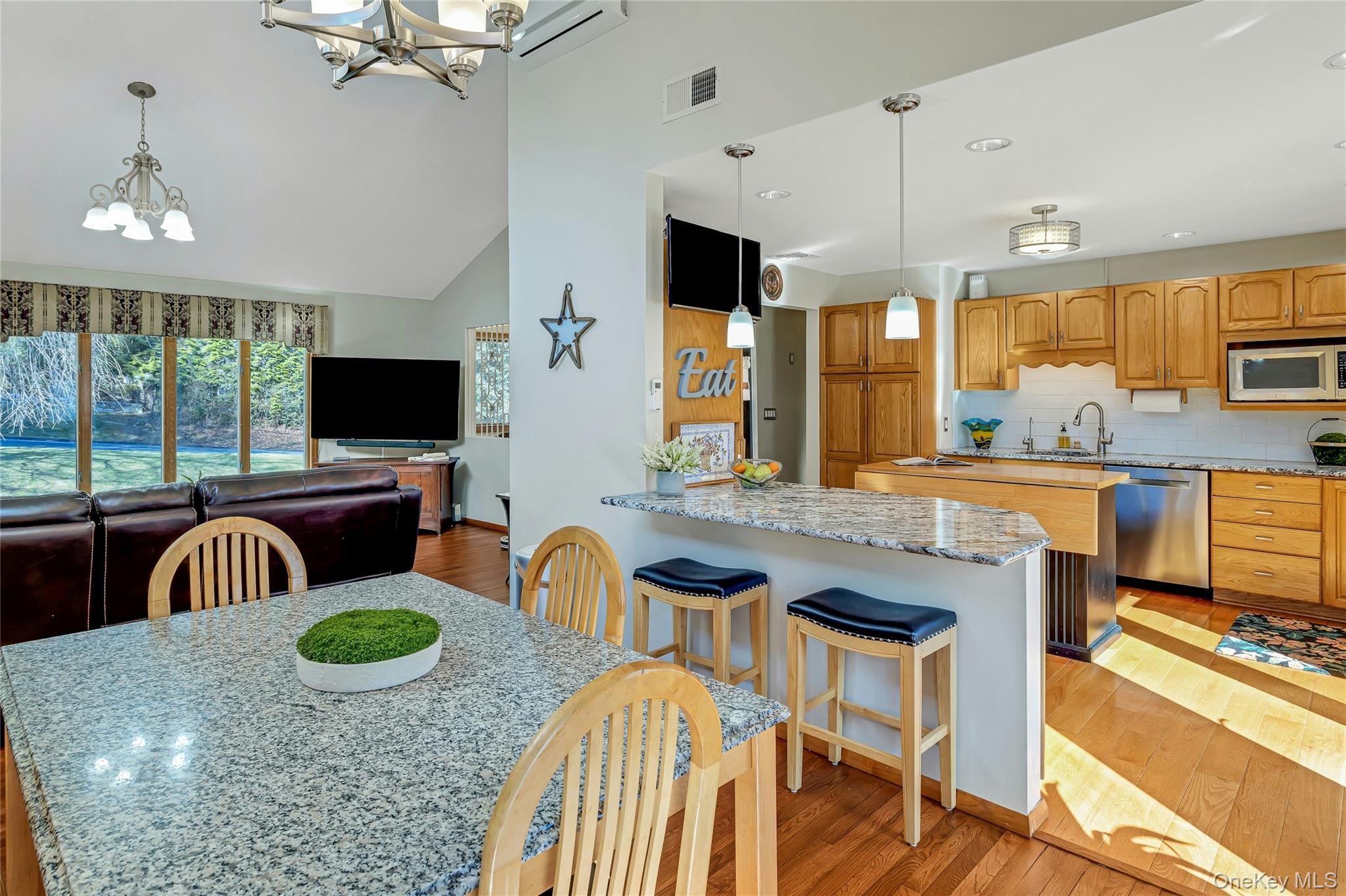 204 Cherry Hill Road Carmel, NY 10512 - Photo 11 of 36 a kitchen with granite countertop a stove a sink a dining table and chairs with wooden floor