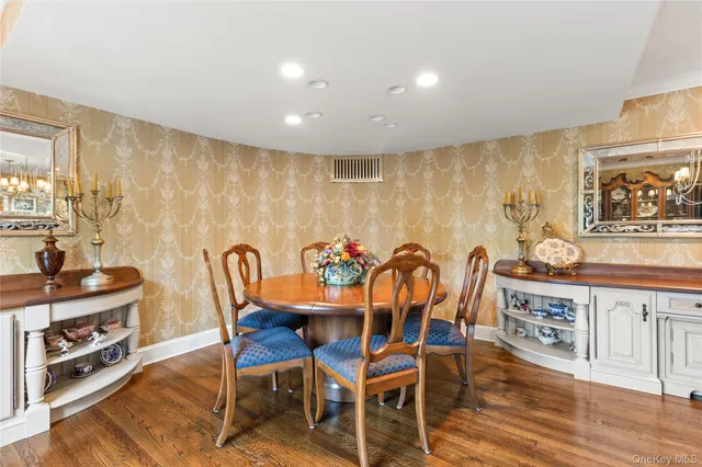 a view of a dining room with furniture a kitchen and chandelier