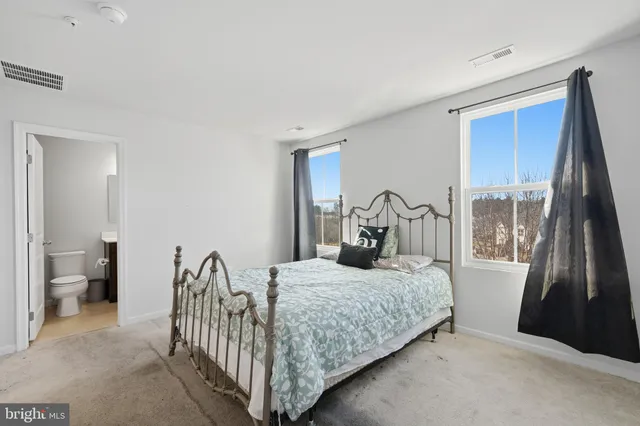 a bedroom with a bed and a large window