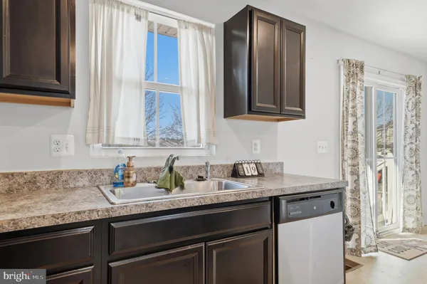 a kitchen with granite countertop stainless steel appliances a sink and a window