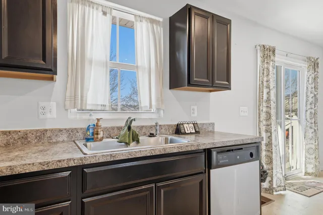 a kitchen with granite countertop stainless steel appliances a sink and a window
