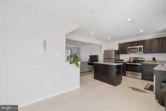 a kitchen with a refrigerator and a stove top oven