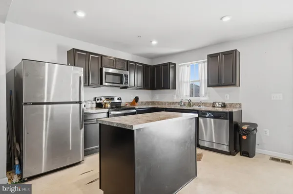 a kitchen with stainless steel appliances granite countertop a refrigerator stove a sink and a microwave