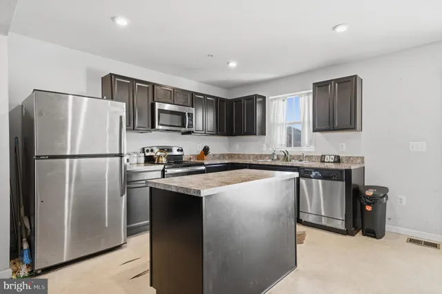 a kitchen with stainless steel appliances granite countertop a refrigerator stove a sink and a microwave