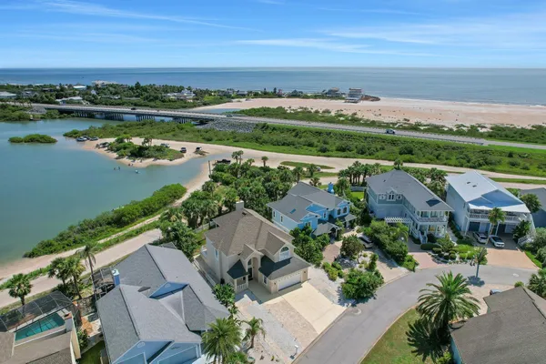 an aerial view of ocean and residential houses with outdoor space