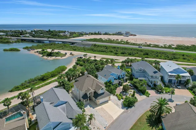 an aerial view of ocean and residential houses with outdoor space