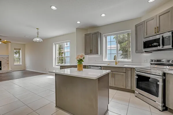 a kitchen with stainless steel appliances granite countertop a sink stove and microwave