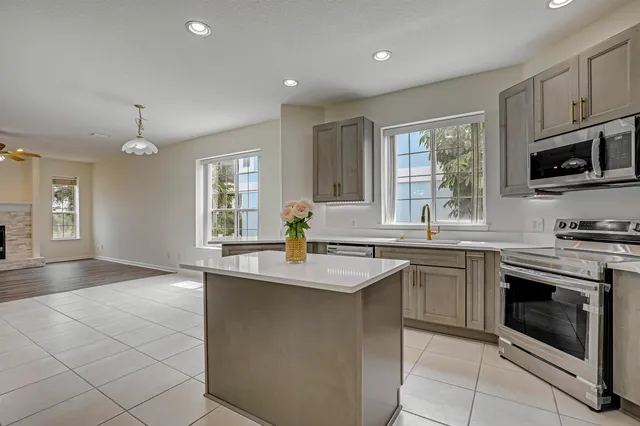 a kitchen with stainless steel appliances granite countertop a sink stove and microwave