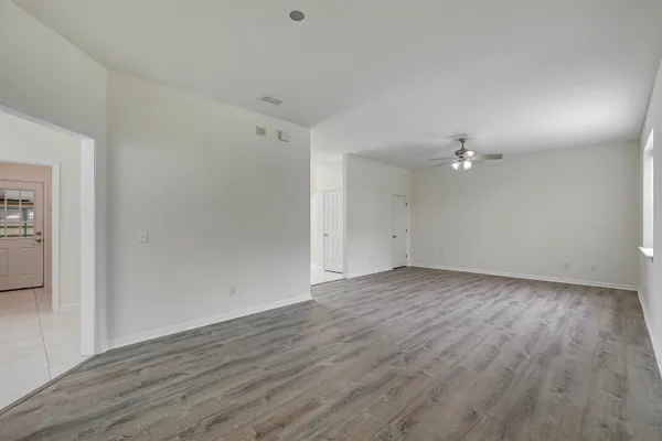 an empty room with windows and fan