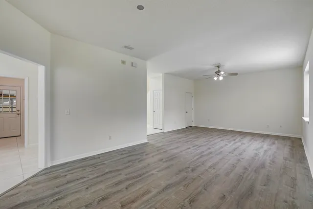 an empty room with windows and fan