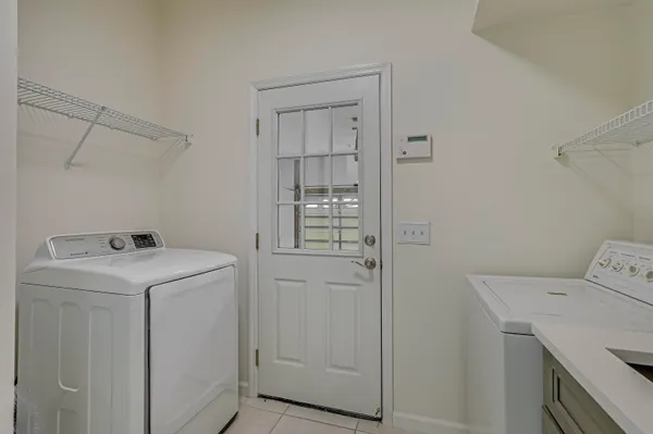 a view of a big room with windows and chandelier fan