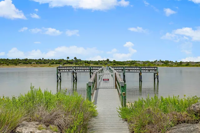 a view of an empty room with wooden floor fireplace and a window