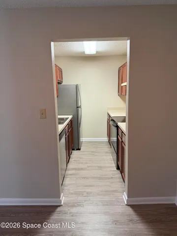 a hallway with wooden cabinets and wooden floor