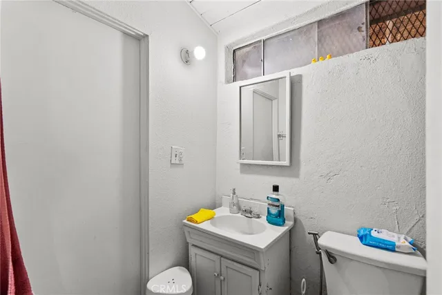 a bathroom with a sink toilet and a mirror