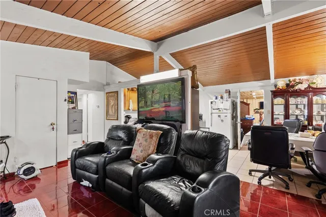 a living room with furniture a flat screen tv and a window