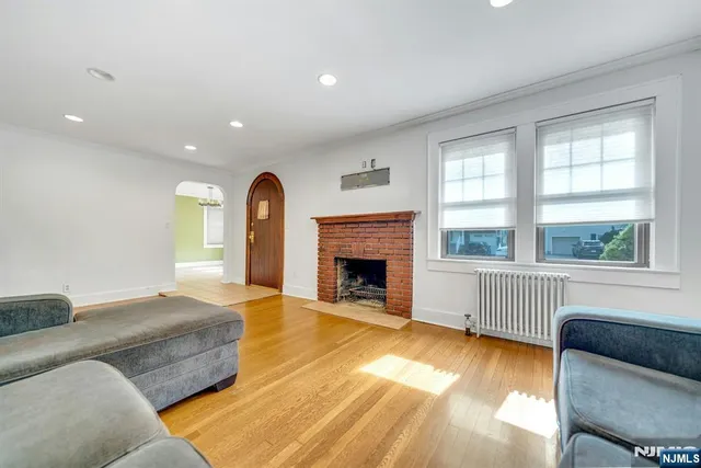 a view of a hallway with wooden floor and a bathroom