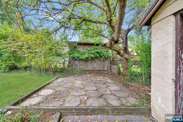 a view of backyard with table and chairs and wooden fence