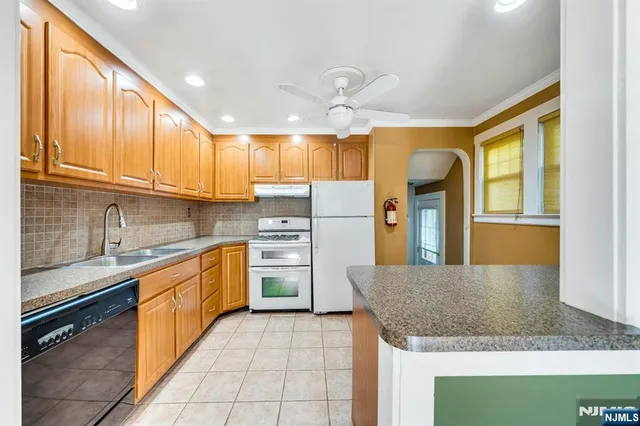 a kitchen with stainless steel appliances granite countertop a sink window and cabinets