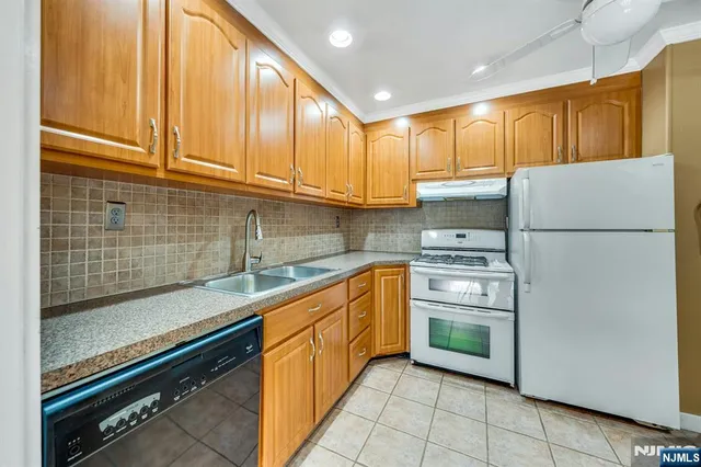 a kitchen with a refrigerator sink and cabinets