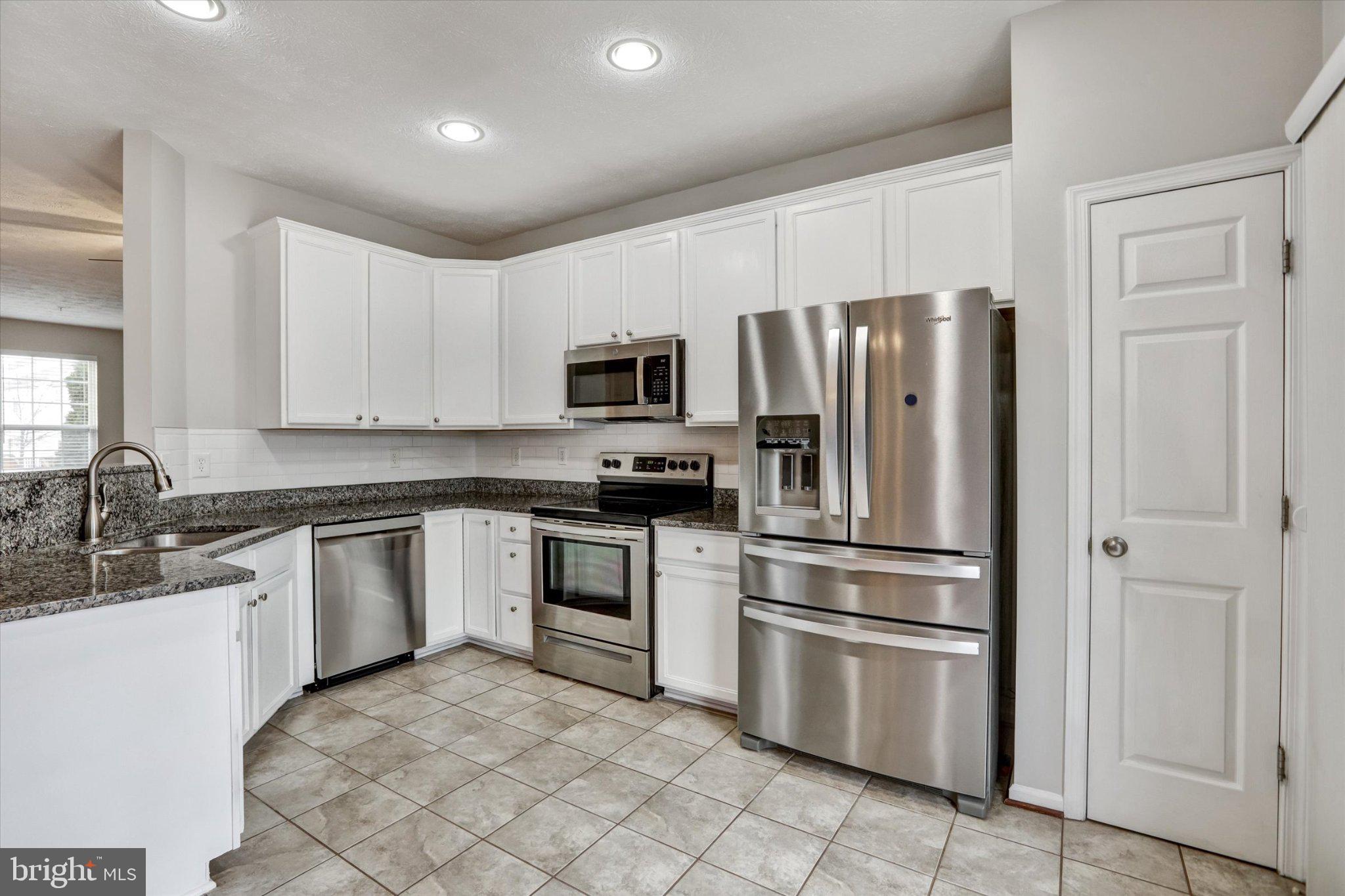 9663 Davison Road Middle River, MD 21220 - Photo 9 of 45 a kitchen with granite countertop a refrigerator stove and microwave