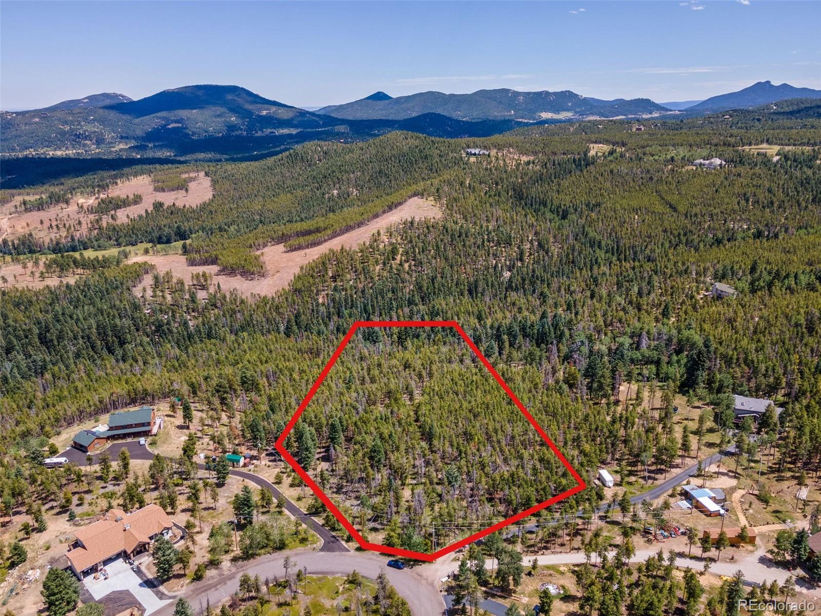 8570 South Warhawk Road Conifer, CO 80433 - Photo 10 of 19 a view of a lush green hillside and a houses