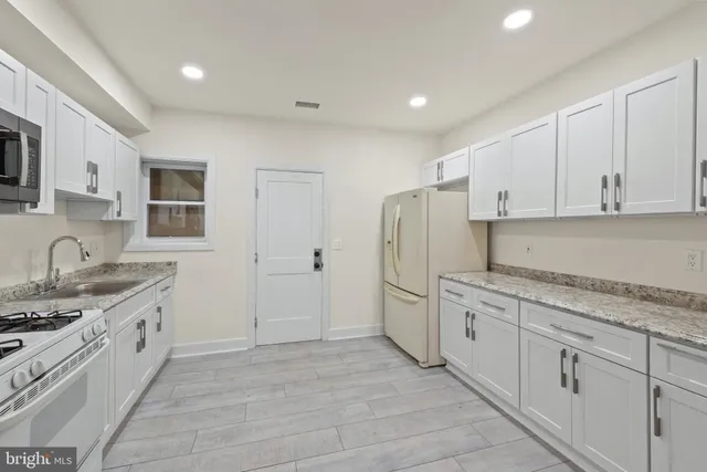 a kitchen with stainless steel appliances granite countertop a refrigerator sink and cabinets