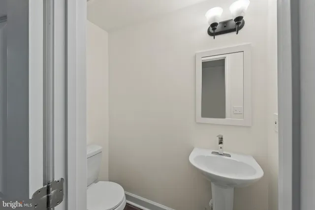 a bathroom with a sink toilet and mirror