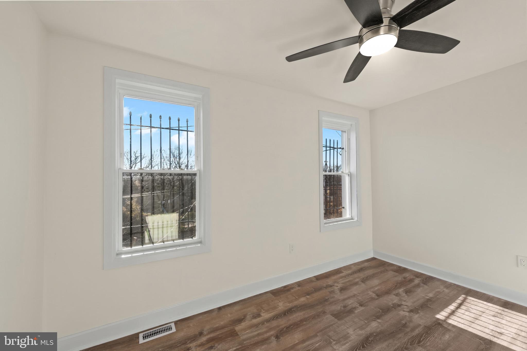 2419 Baker Street Baltimore, MD 21216 - Photo 21 of 40 a view of empty room with wooden floor and fan