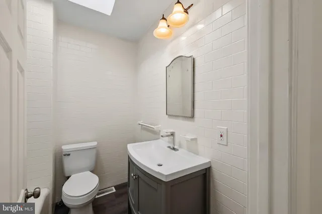 a bathroom with a toilet sink and mirror