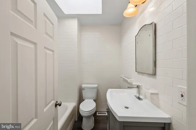 a bathroom with a sink mirror and toilet