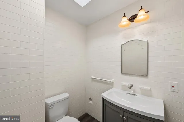 a bathroom with a sink mirror and toilet
