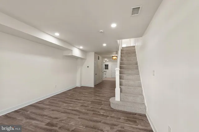 a view of an empty room with stairs and ventilation