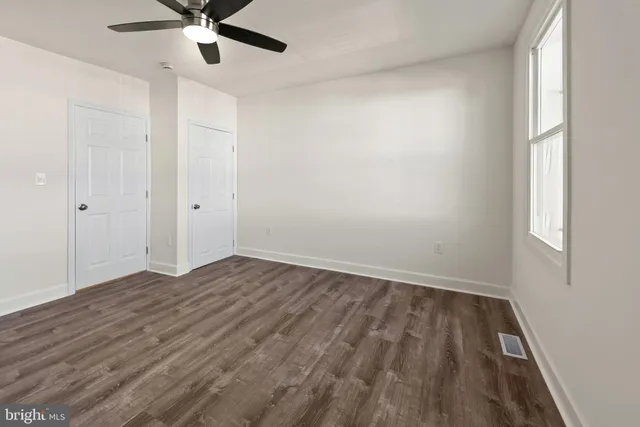 wooden floor in an empty room with a window